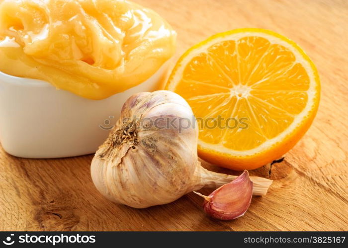 Natural healing, alternative medicine. Healthy ingredients for strengthening immunity. Honey garlic and lemon on wooden rustic table.