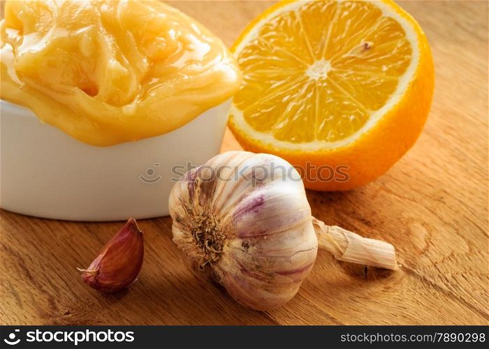 Natural healing, alternative medicine. Healthy ingredients for strengthening immunity. Honey garlic and lemon on wooden rustic table.
