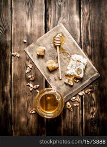 Natural honey in honeycombs with a spoon on the Board. On wooden background.. Natural honey in honeycombs with a spoon on the Board.