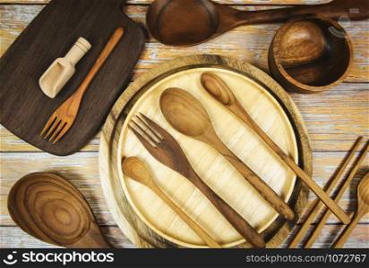 Natural kitchen tools wood products / Kitchen utensils background with spoon fork chopsticks bowl plate cutting board object , top view on the table utensil wooden concept