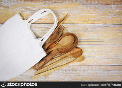 Natural kitchen tools wood products / Kitchen utensils background with spoon fork chopsticks plate cutting board object and cloth bag , top view on the table utensil wooden concept