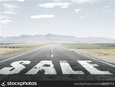 Natural landscape of asphalt road and drawn conceptual word on it. Sale word on asphalt road