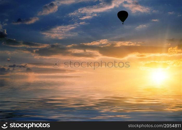 natural landscape with cloudy sky at sunset and air balloon reflected in water. sky and air balloon reflected in water