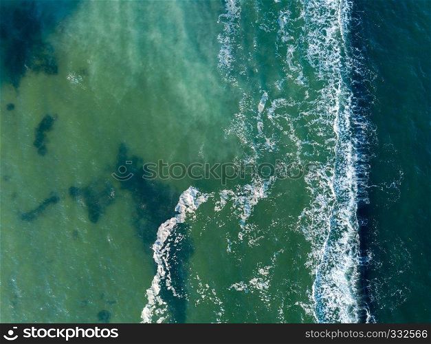 Natural marine seascape with turquoise deep clear water and foam waves. Aerial view from drone. Aqua background with place for text.. Abstract turquoise sea water with white foam waves for natural background. Aerial top view from drone above ocean. Copy space.