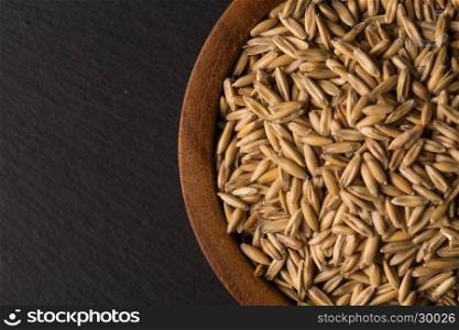 natural oat grains in bowl for background, close up shot