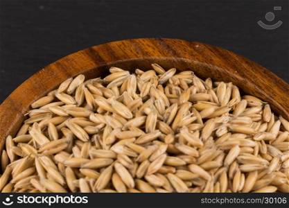 natural oat grains in bowl for background, close up shot