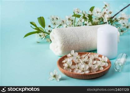 Natural organic beauty products for spa and aromatherapy. Aromatic essential oil, candles and a towel on a blue background. Relaxation concept, place for text.. Natural organic beauty products for spa and aromatherapy. Aromatic essential oil, candles and a towel on a blue background. Relaxation concept