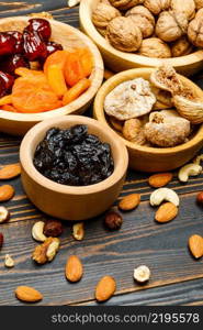 natural organic dried fruits and nuts on wooden background. dried fruits figs, apricots, plums and nuts on wooden background