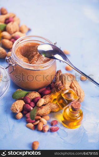 Natural peanut butter. Natural peanut butter with oil in a glass jar and peanuts