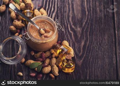 Natural peanut butter. Natural peanut butter with oil in a glass jar and peanuts