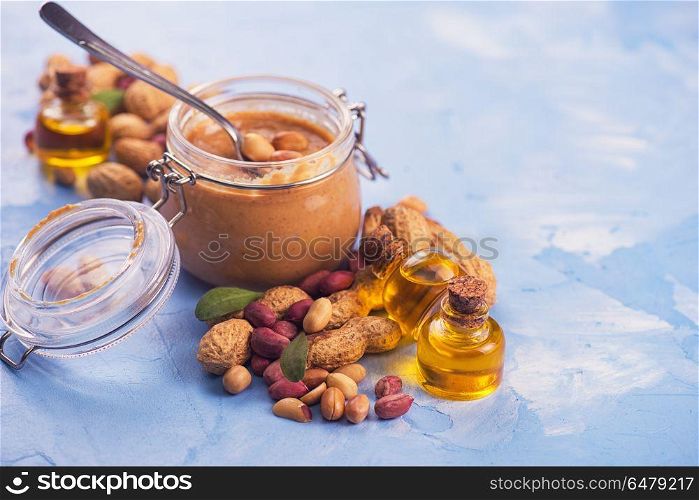 Natural peanut butter. Natural peanut butter with oil in a glass jar and peanuts