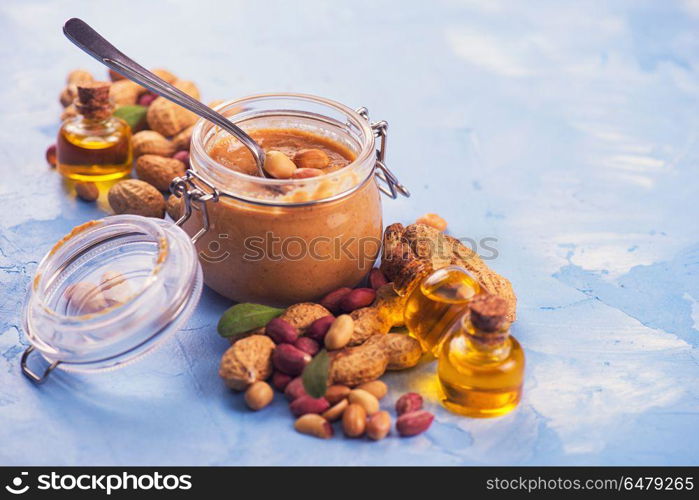 Natural peanut butter. Natural peanut butter with oil in a glass jar and peanuts