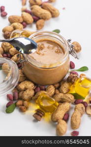 Natural peanut butter. Natural peanut butter with oil in a glass jar and peanuts