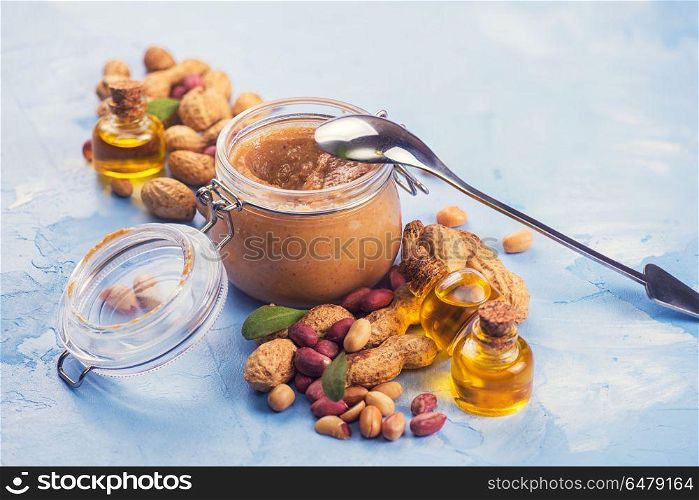 Natural peanut butter with oil in a glass jar and peanuts. Natural peanut butter. Natural peanut butter