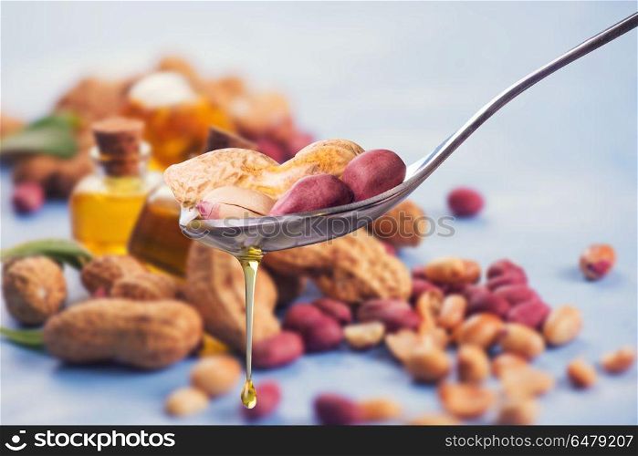 Natural peanut oil. Natural peanut oil with spoon and nuts