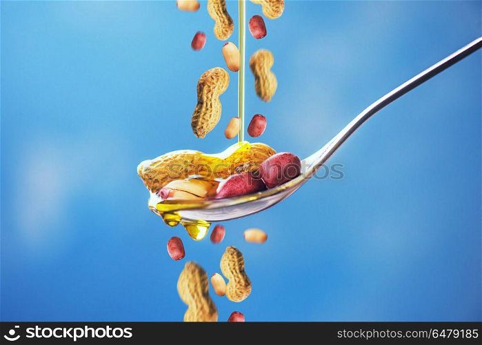 Natural peanut oil with spoon and nuts. Natural peanut oil. Natural peanut oil