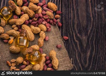 Natural peanut with oil in a glass. Natural peanuts with oil in a glass jar on the wooden background