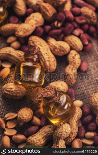 Natural peanut with oil in a glass. Natural peanuts with oil in a glass jar on the wooden background