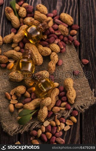 Natural peanut with oil in a glass. Natural peanuts with oil in a glass jar on the wooden background