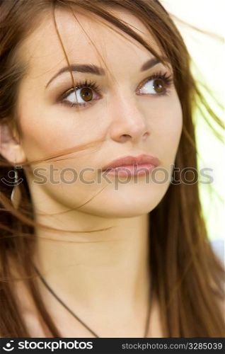 Natural portrait of a beautiful brunette with windswept hair