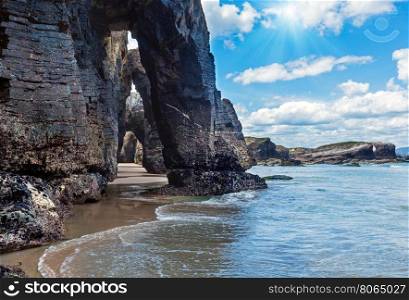 Natural rock arches on Cathedrals beach in low tide (Cantabric coast, Lugo (Galicia), Spain) and sunshine.