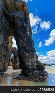Natural rock arches on Cathedrals beach  in low tide  Cantabric coast, Lugo, Galicia, Spain .