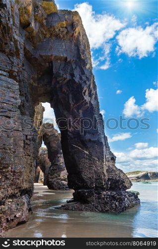 Natural rock arches on sunshiny Cathedrals beach in low tide (Cantabric coast, Lugo (Galicia), Spain).