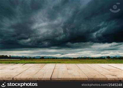 Natural scenic beautiful field storm clouds and Empty wood table for product display and montage.