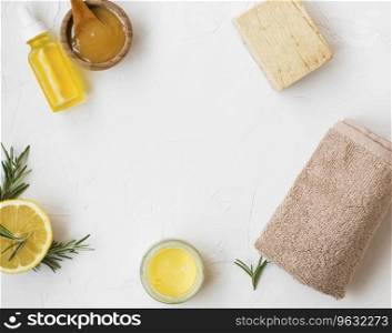 Natural skincare ingredients composition top view with copy space, manuka honey, lemon and rosemary herb, natural soap, towel, natural spa still life