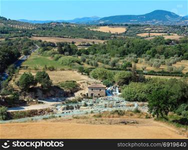 Natural spa with waterfalls and hot springs at Saturnia thermal baths, Grosseto, Tuscany, Italy. People unrecognizable.