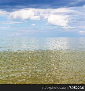 natural square background - Azov Sea seascape with calm green water and blue sky with white and rain clouds. Temryuk bay, Golubitskaya resort, Taman peninsula, Kuban, Russia