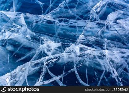 Natural texture of transparent clear ice of a lake with cracks. Many cracks in thick ice. Horizontal.