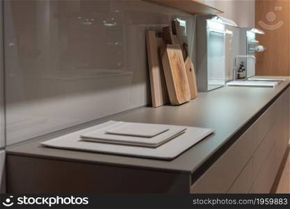 Natural Tone Kitchen Counter with Square Flat Plates and Wooden Chopping Boards