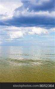 natural vertical background - Azov Sea waterscape with calm green water and blue sky with white and rain clouds. Temryuk bay, Golubitskaya resort, Taman peninsula, Kuban, Russia