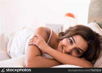Natural woman lying on the bed smiling