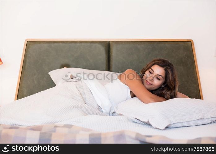 Natural woman lying on the bed smiling