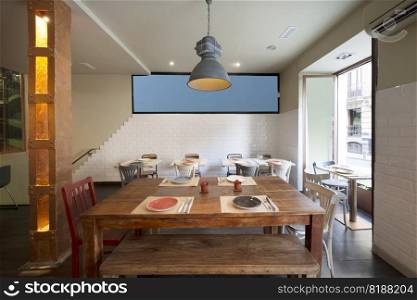 Natural wood dining tables with catering set up in a restaurant