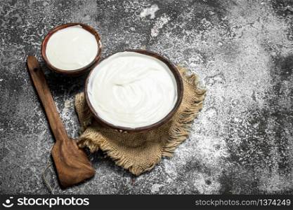 Natural yogurt in a bowl. On a rustic background.. Natural yogurt in a bowl.