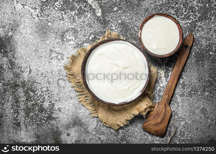 Natural yogurt in a bowl. On a rustic background.. Natural yogurt in a bowl.