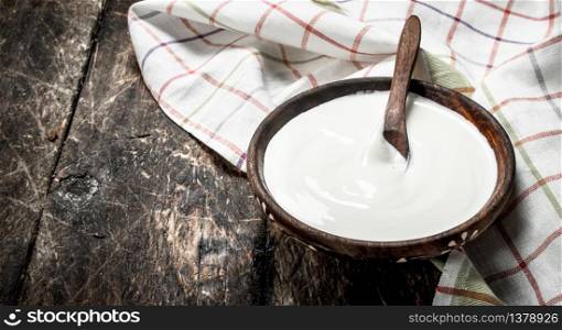 Natural yogurt in a bowl. On a wooden background.. Natural yogurt in a bowl.
