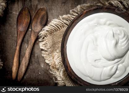 Natural yogurt in a bowl. On a wooden background.. Natural yogurt in a bowl.