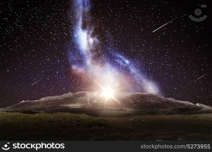 nature and astronomy concept - mountain landscape over night sky or space with shooting stars and galaxy background. mountain landscape over night sky or space