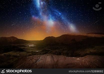 nature and astronomy concept - mountain landscape over night sky or space with shooting stars background. mountain landscape over night sky or space