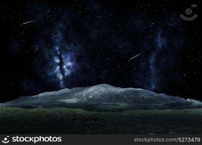 nature and astronomy concept - mountain landscape over night sky or space with shooting stars background. mountain landscape over night sky or space