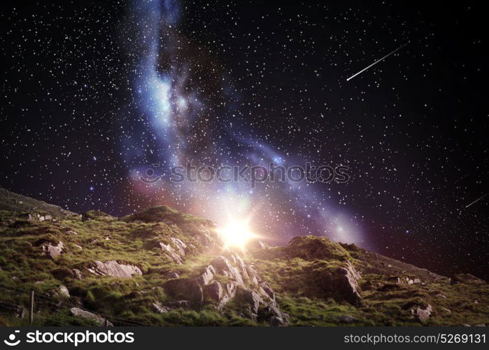 nature and astronomy concept - rocky landscape over night sky or space with shooting stars background. rocky landscape over night sky or space