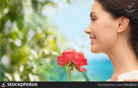 nature and beauty concept - smiling woman smelling flower - smiling woman smelling flower