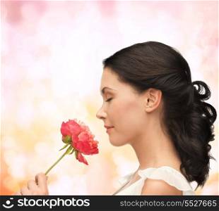 nature and beauty concept - smiling woman smelling flower with eyes closed