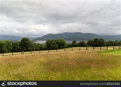 nature and landscape concept - view to lake or river, hills and farmland at connemara in ireland