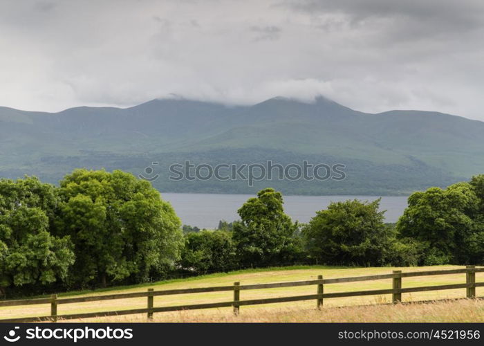 nature and landscape concept - view to lake or river, hills and farmland at connemara in ireland