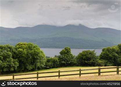 nature and landscape concept - view to lake or river, hills and farmland at connemara in ireland